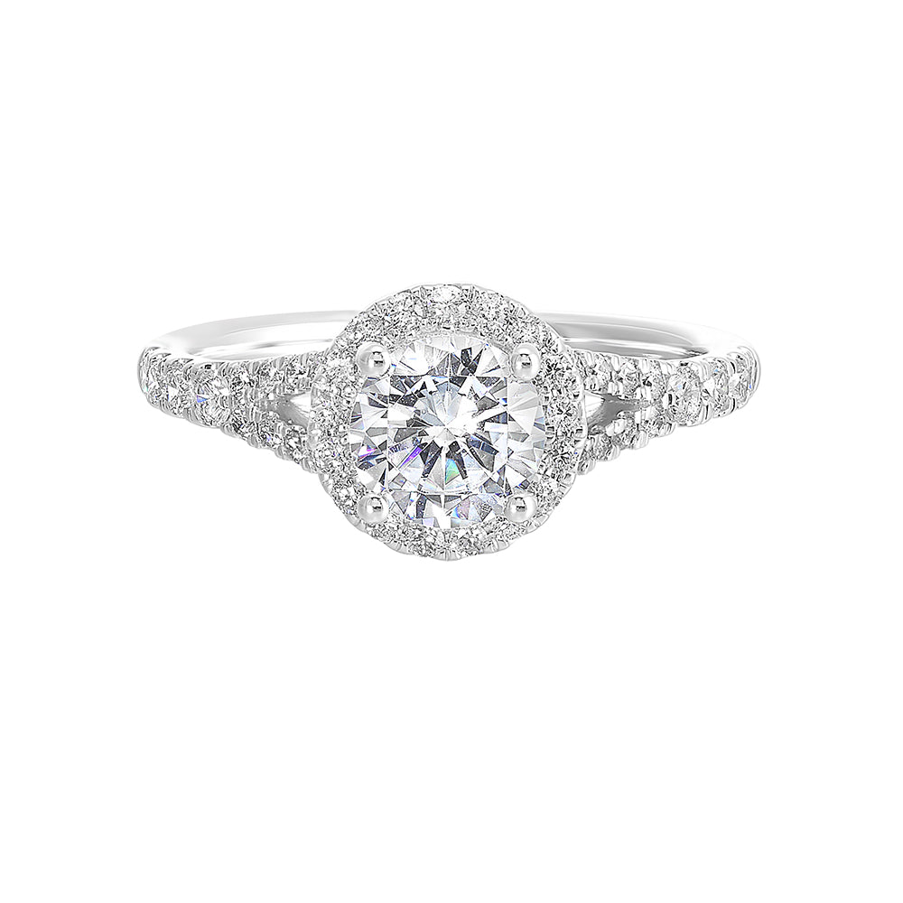 This ring stuns with a round solitaire embraced by a halo and a delicate split shank. Its a unique symbol of your love story.