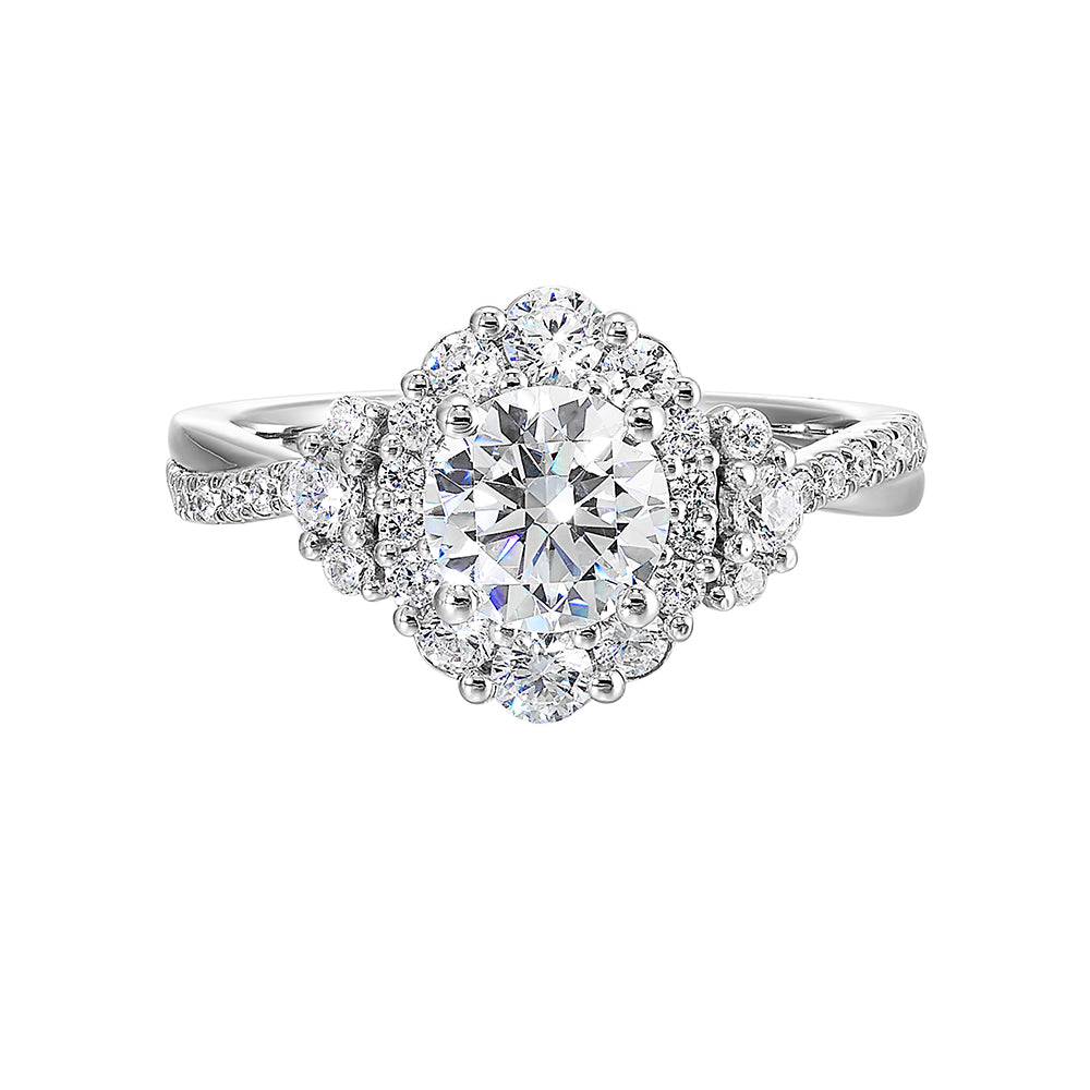 A mesmerizing oval halo ring with graduating diamonds and half moon diamond cluster on either side adds a touch of brilliance and elegance with twisted shank.