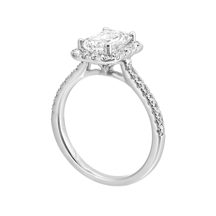 A beautiful emerald cut solitaire set with halo of round diamonds and a diamond studded shank makes this perfect choice of your love story.
