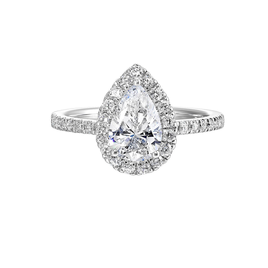 The pear cut solitare shines in this elegant ring, embraced by a delicate halo. The diamond shank adds a touch of sparkle, showcasing the beauty of the pear and halo at its finest.