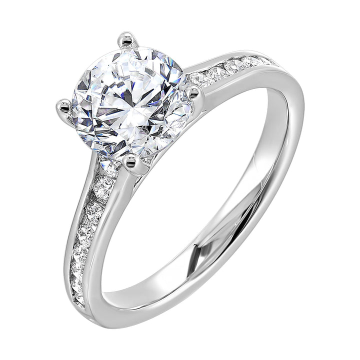 The simplicity of this single row channel set diamond shank engagement ring with four prong solitaire is simply gorgeous.