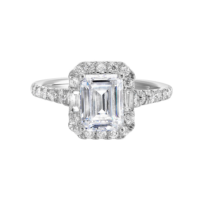 A glittering softened halo of diamonds surrounds the center emerald with adjacent baugettes on both the sides. Pave split shank adds a stylish, dazzling look.