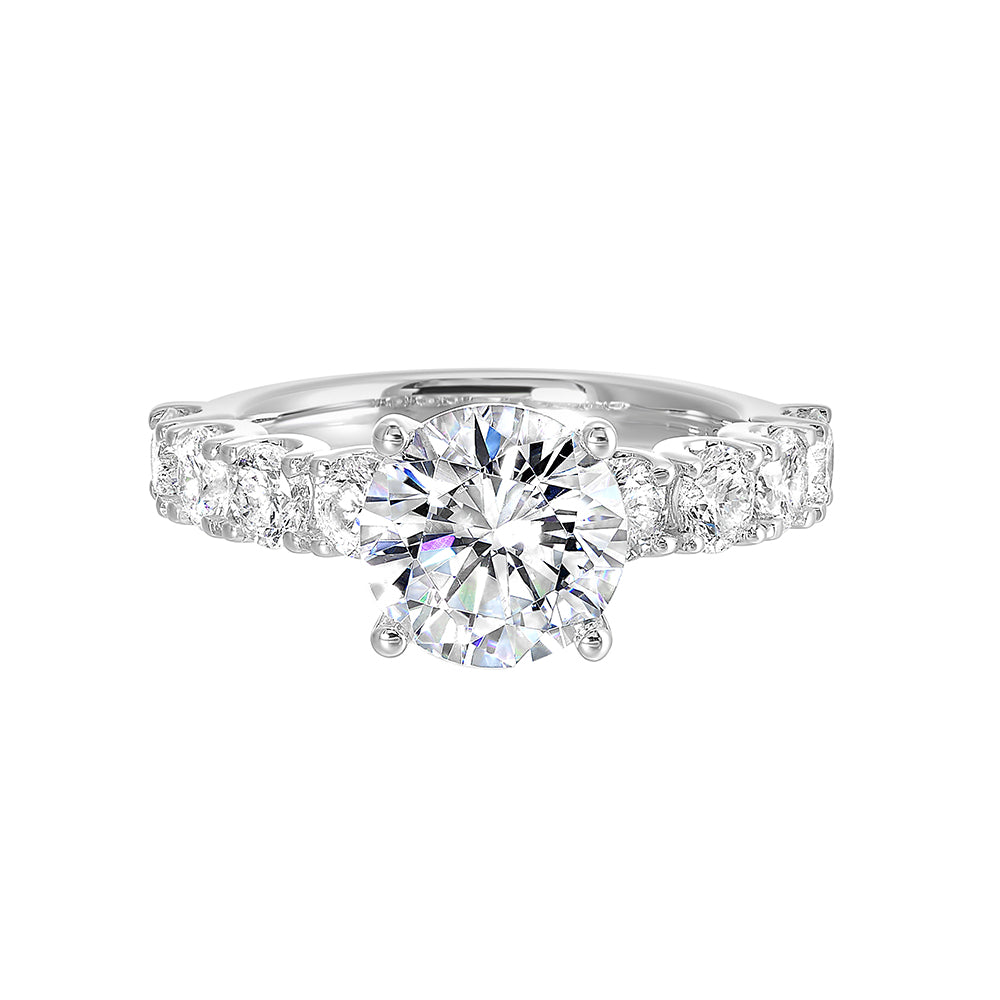 A solitaire engagement ring accommodates sparkling round diamonds of considerable size along the shank giving luxurous look.